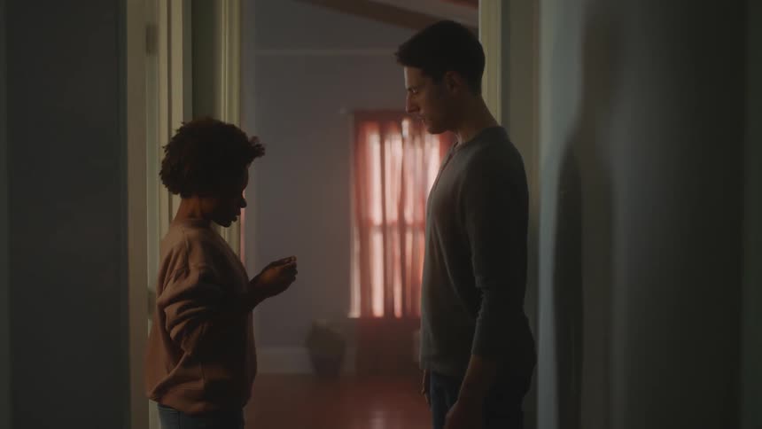 A man waits anxiously for his partner to leave the bathroom with a pregnancy test and when she does they celebrate with a hug