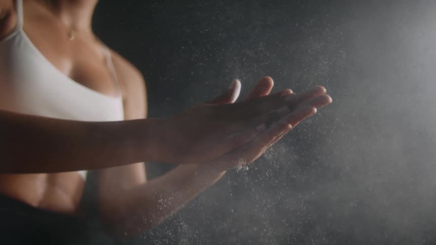 A woman rubbing her hands which are full of white powder