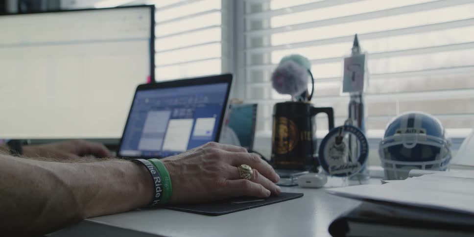 Closeup of hands on a table working on a laptop and computer