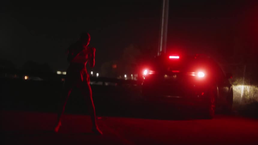 Muay thai fighter shadowboxing on the road of an urban area during night time