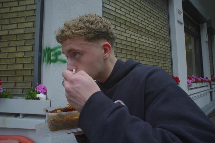Man standing and eating a packed lunch