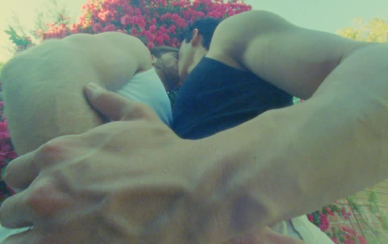 Two men holding hands and kissing passionately