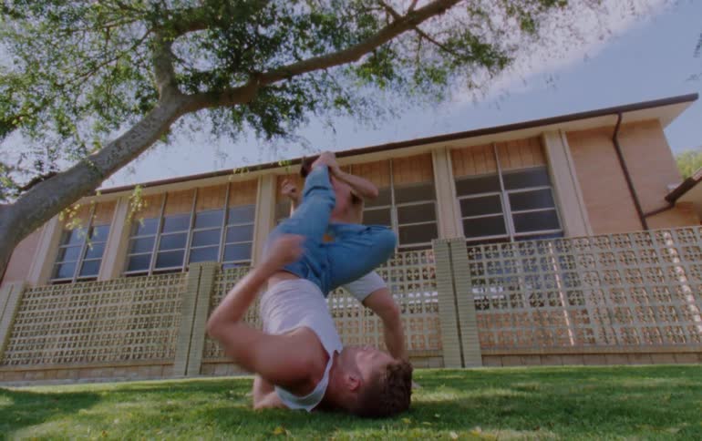 Two men in an outdoor setting dancing a choreography together