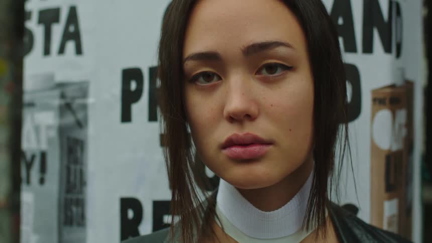 A closeup of a young womans face on a cloudy day