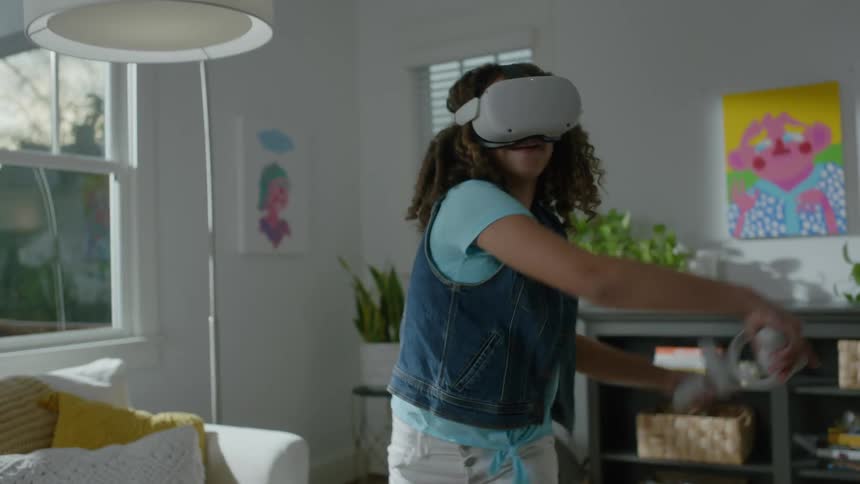 Young teenager girl playing a game with a vr headset in a living room during day time