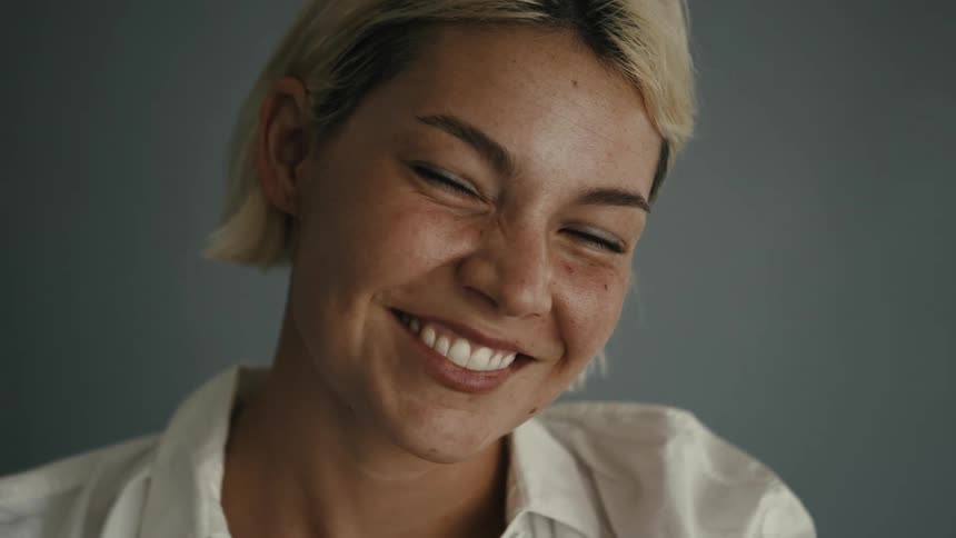 A portrait of a youthful blonde woman as she smiles and laughs