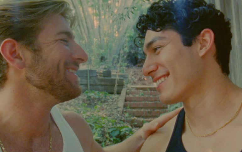 Closeup of two men looking at each other and smiling romantically