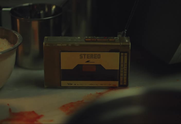 Red sauce splatters across counter near stereo device