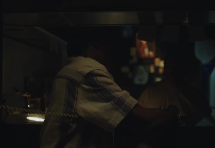 Man answers a phone call at a dimly lit restaurant