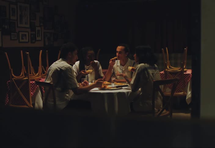 A group of friends sitting around a table eating and talking