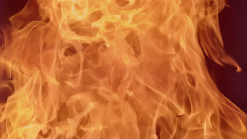 Close up of a large fire with tall flames filling the area creating orange and red light