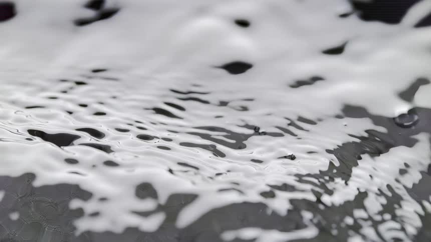 Small ripples on the surface of a clear water puddle