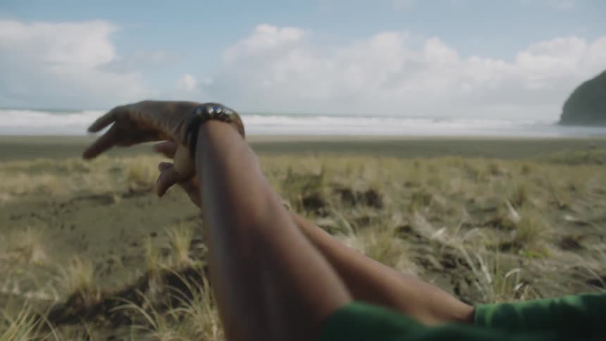 A man performing arm dance moves on the beach