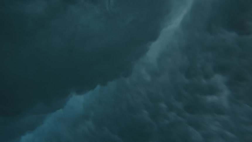 Underwater footage of an ocean wave rolling and breaking over