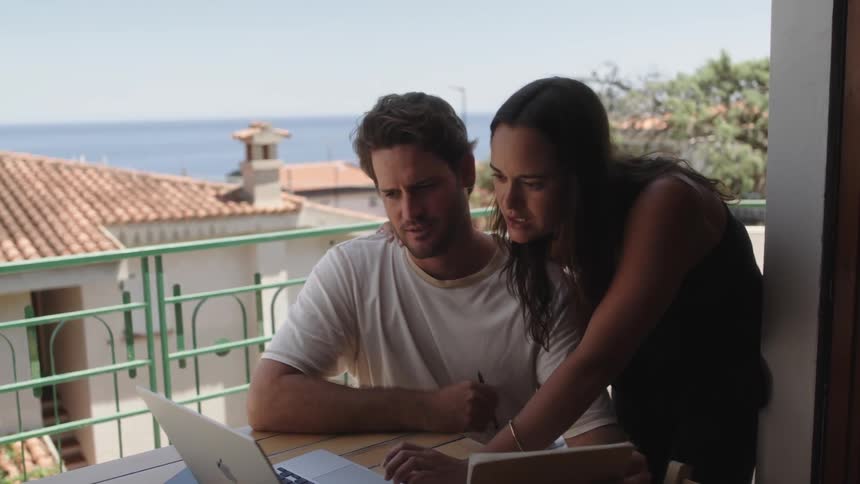 A couple of a man and a woman talking to someone on the laptop