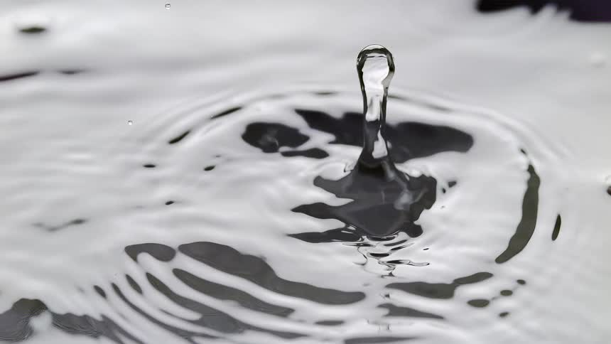 Closeup of a water droplet falling and creating ripples