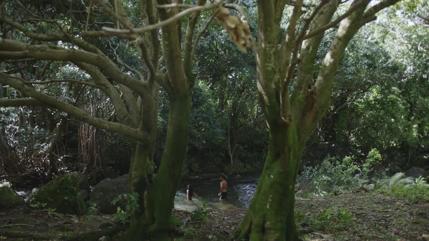 A man and woman are splashing in the stream together