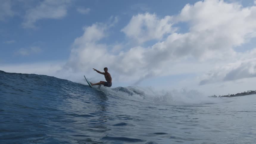 Man surfing over a wave near the coast