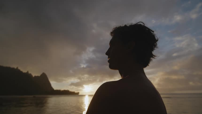 A man standing on a beach at dusk