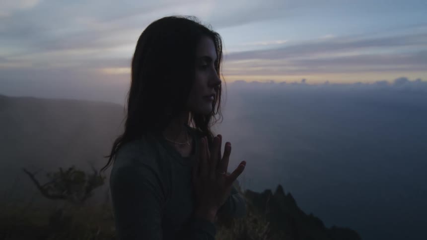 A woman is praying on the mountain top