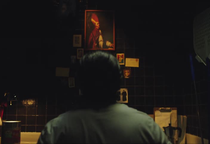 A darkskinned man looking at a painted picture of a person