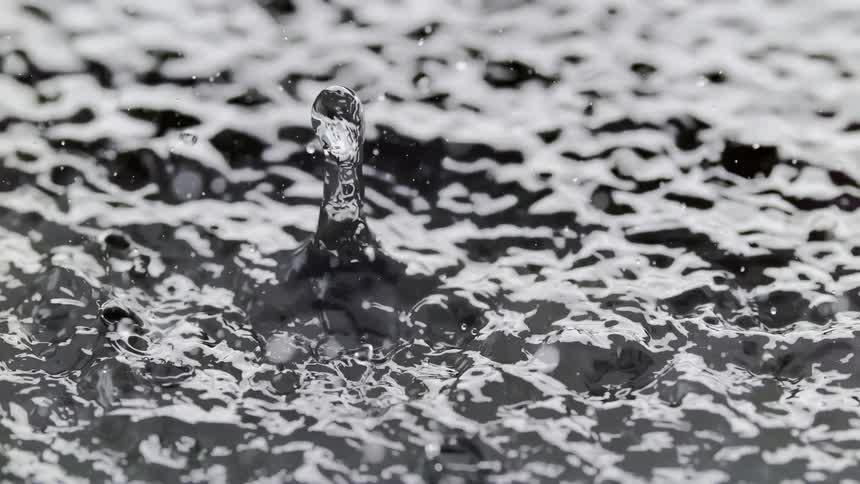 Close up of water droplets splashing into water during the day