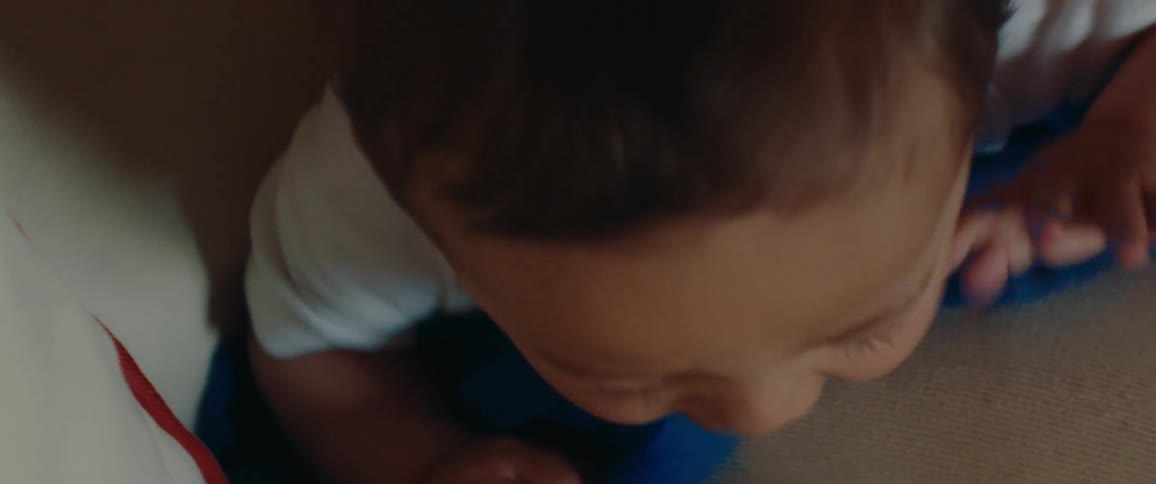 Baby smiling while laying on the bed, looking to camera