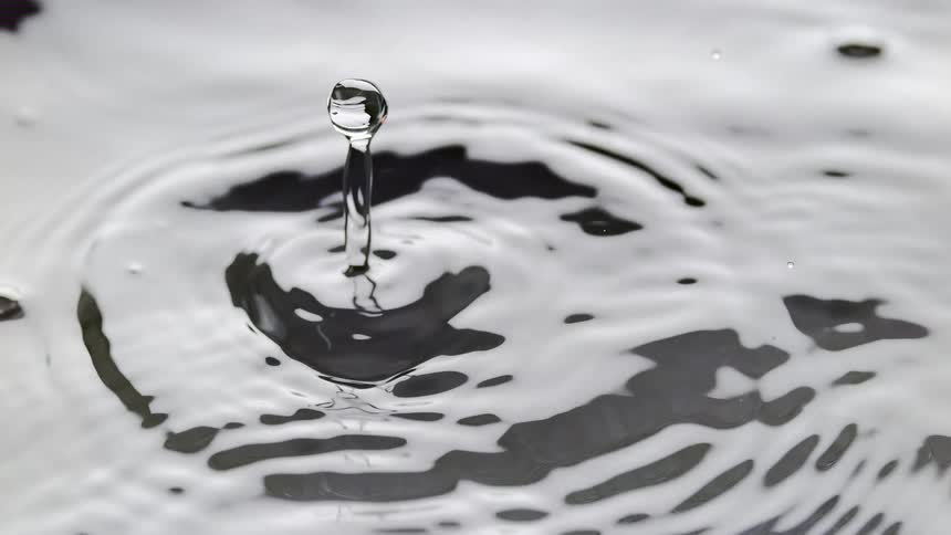 A water droplet as result to an item dropped into the water with vibration seen in the water