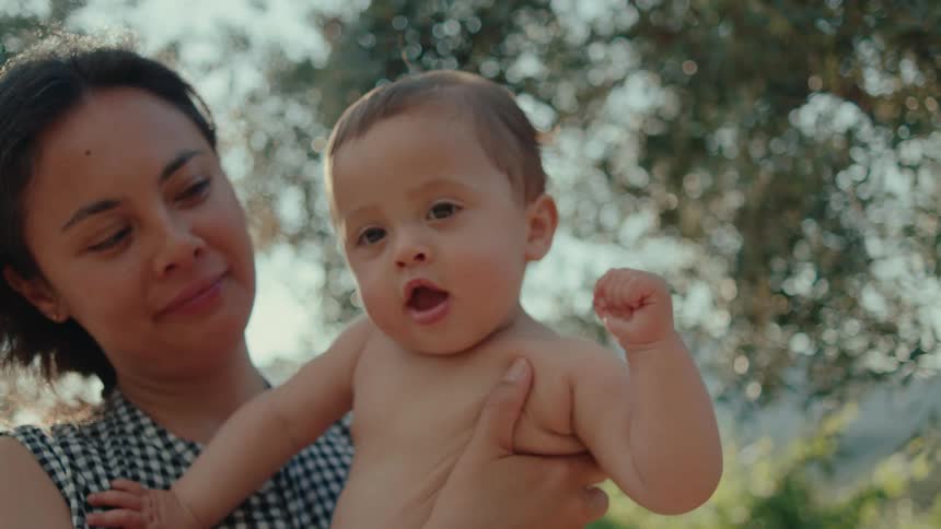 A mother and child share a sweet moment and the child looks to camera for a moment