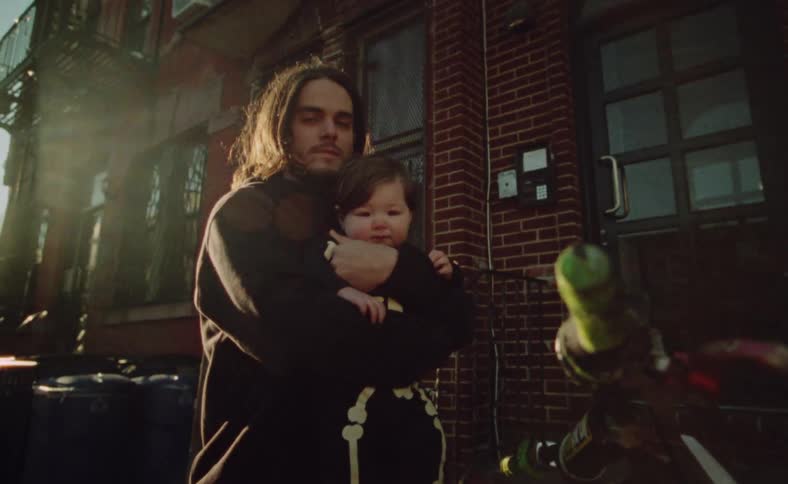 A man on a parked motorcycle holding a baby