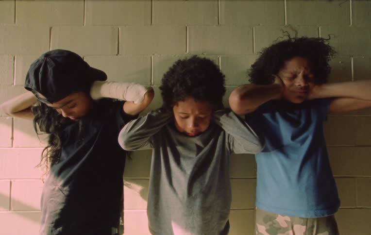 Three children covering their ears and making an expression of something chaotic