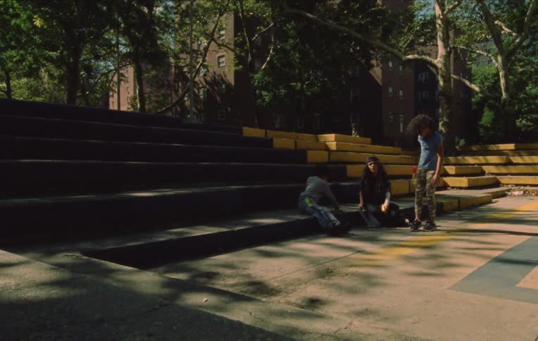 Friends sit on steps near empty plaza with water guns