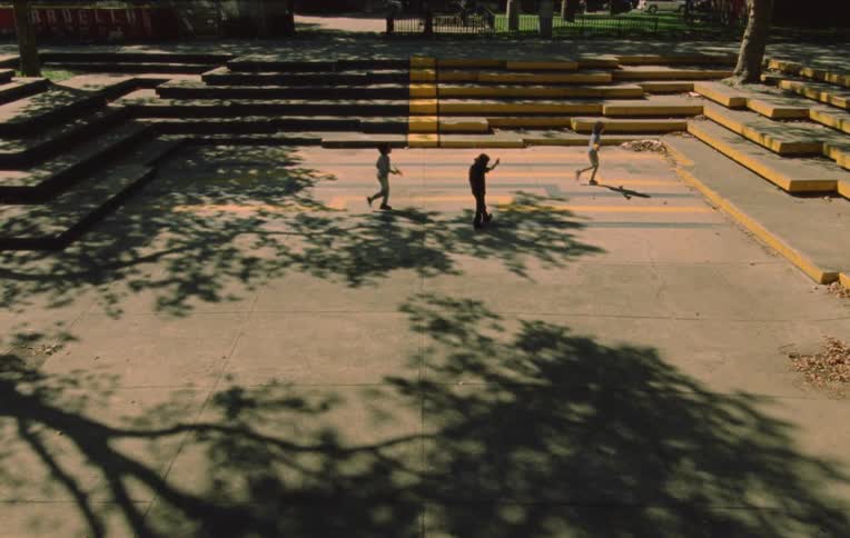 Three children running and playing among themselves in a public setting