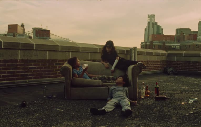 Three children on a sofa chatting on the terrace of a building
