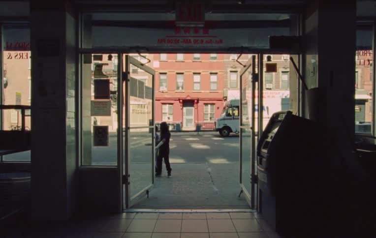 Three children walk down street by a store two walk inside