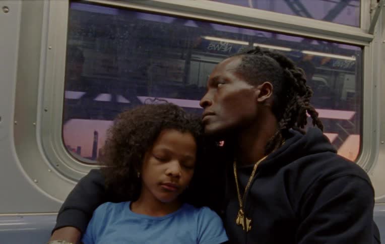 A father rides the New York City subway while holding his daughter in his arms
