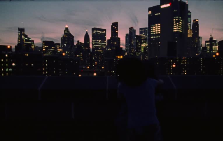 Group of boys and girls playing on the roof of a building in the city at evening