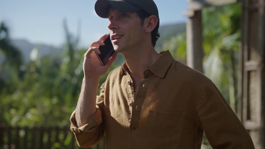 A man is talking on his phone on a sunny day