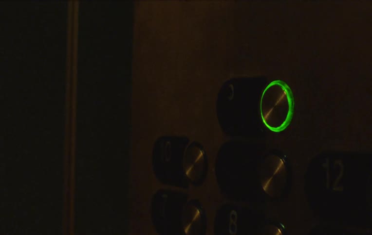 A woman pressing on the elevator button