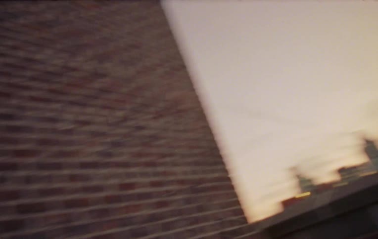 Three children playing on the rooftop of a building attacking objects on the wall and smiling
