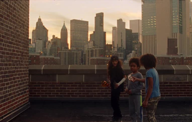 Three children throwing bottles at the wall on the roof top