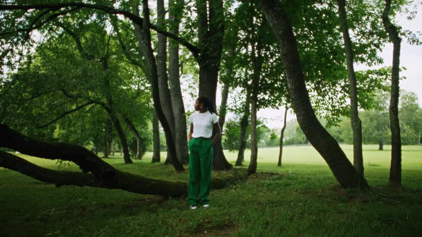A woman is standing near a tree