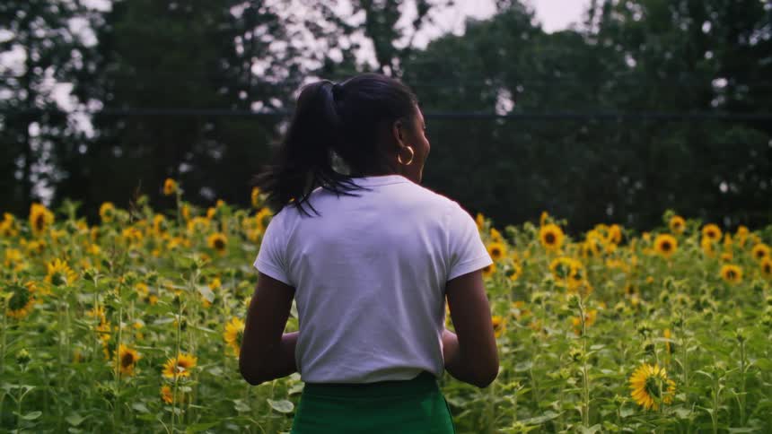 A woman standing in a field of sunflowers