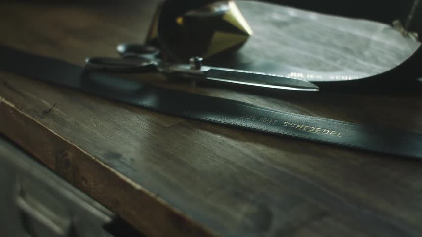 A hacksaw and scissors on a wooden table