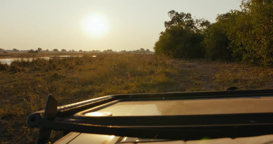 The vehicle is driving past the river
