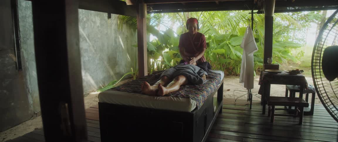 A woman lying in bed receives a relaxing massage