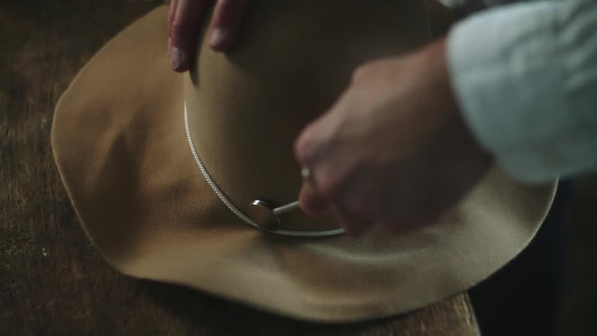 A person is making a hat with a tool