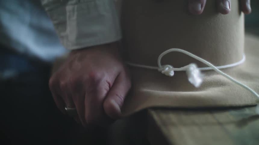 Closeup of a person manufacturing and finishing a sun hat