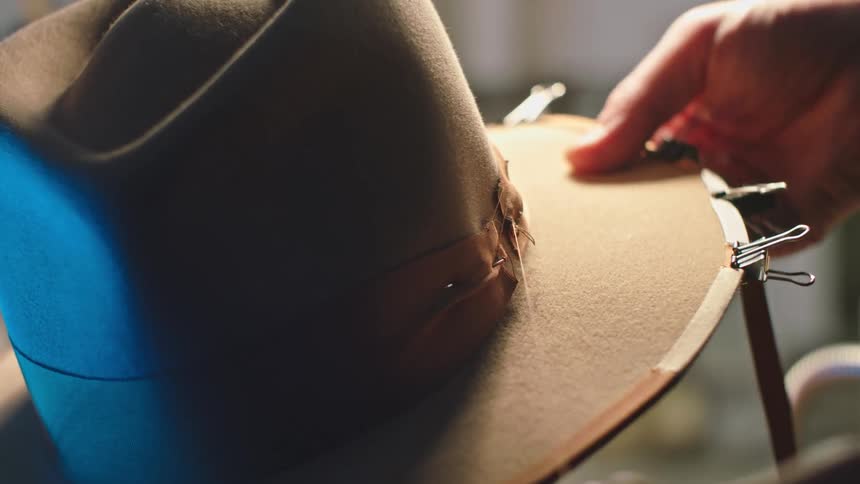 Man sews sun hat
