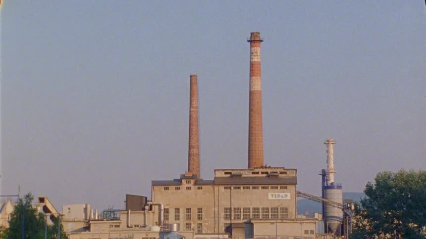Large chimneys sit on top of factory near mountains